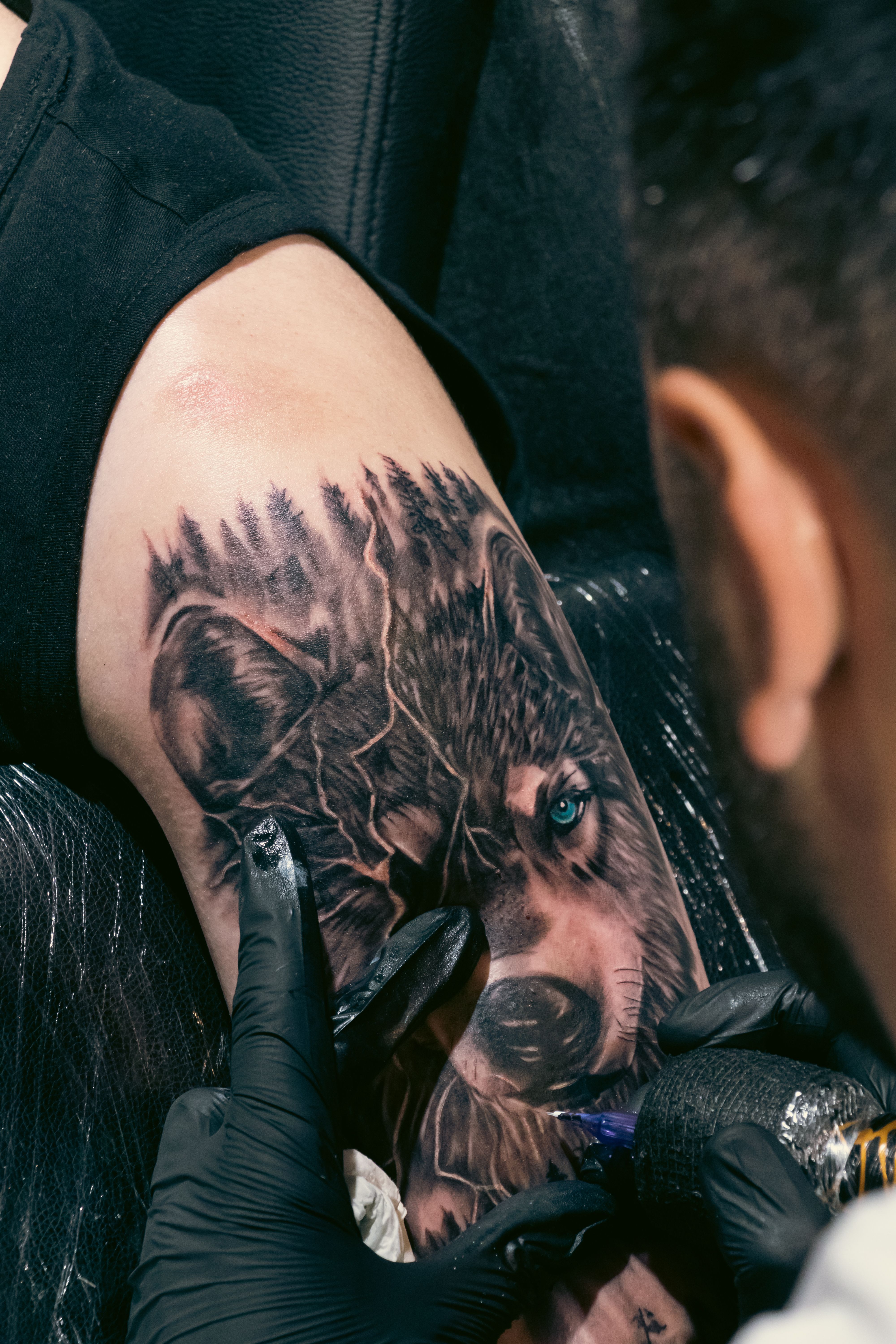Lobo uivando tatuado no braço masculino